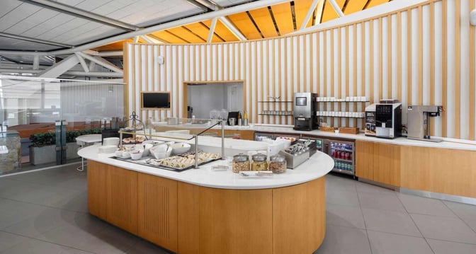 The SkyTeam Lounge at Vancouver International Airport features a self-serve food station with sandwiches, snacks, and a beverage area.