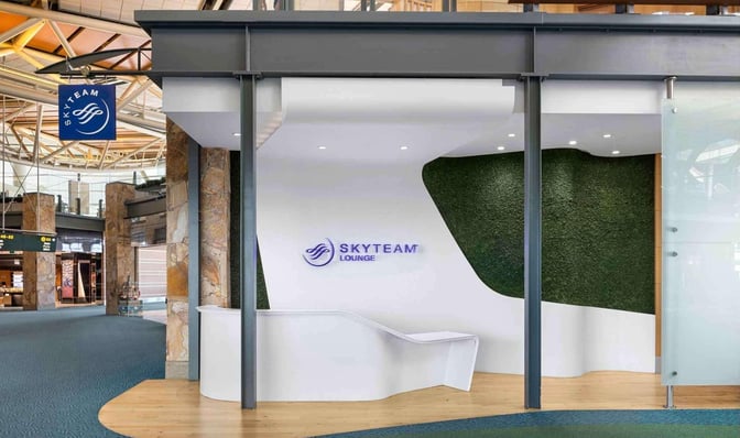 The SkyTeam Lounge entrance at Vancouver International Airport features a sleek design with a prominent logo and adjacent seating area.