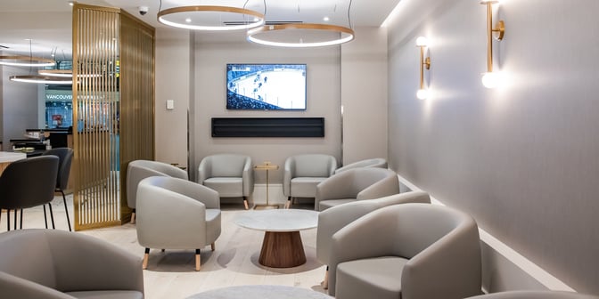 The seating area at Plaza Premium US Transborder Lounge in Vancouver International Airport features comfortable chairs and a television for entertainment.