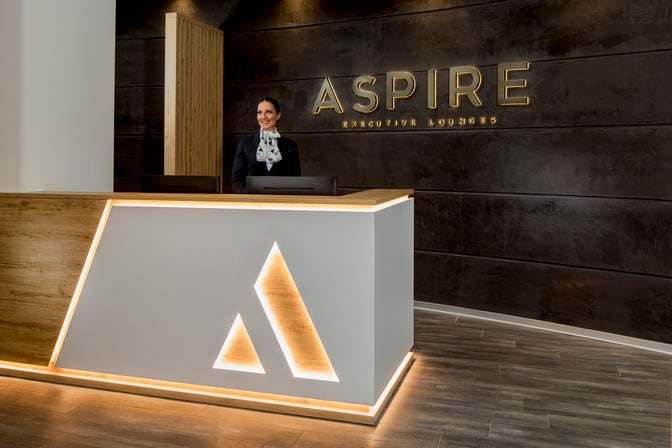 The reception area of the Aspire Executive Lounge at Venice Marco Polo Airport features a staffed desk for guest check-in.