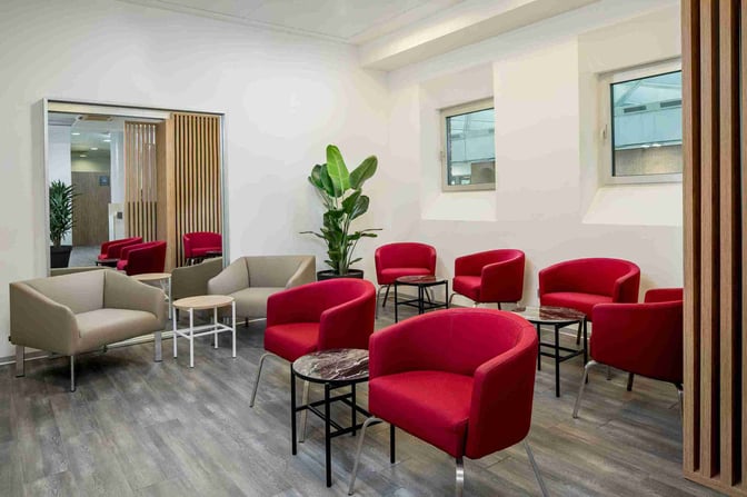 The seating area in the Aspire Executive Lounge at Venice Marco Polo Airport features comfortable chairs and small tables for relaxation.