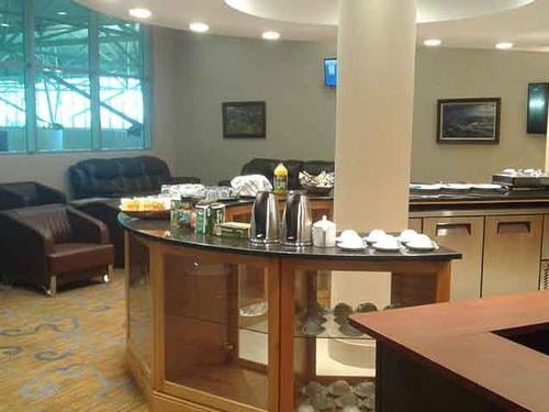 The Khami Lounge at Victoria Falls Airport features a self-serve beverage station with seating areas for passenger relaxation.
