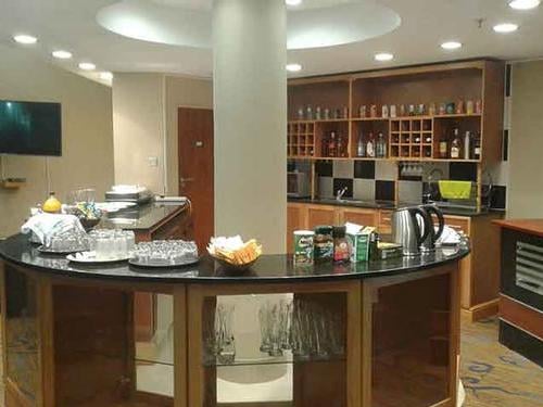 The Khami Lounge at Victoria Falls Airport features a self-serve beverage station with a variety of drinks and glassware available.