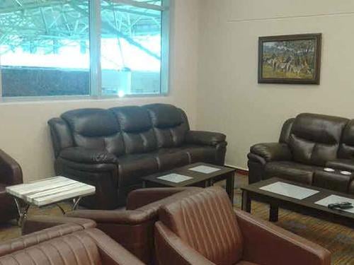 The seating area in Khami Lounge at Victoria Falls Airport features comfortable sofas and chairs with tables, providing a relaxing space for travelers.