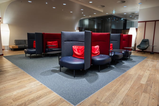 Semi-private seating in the Austrian Business Lounge at Vienna Airport offers circular booths with small tables for passenger comfort.