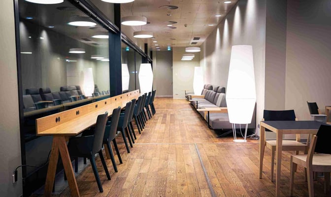 The Austrian Business Lounge at Vienna International Airport features a seating area with workstations, lounge chairs, and tables for travelers.
