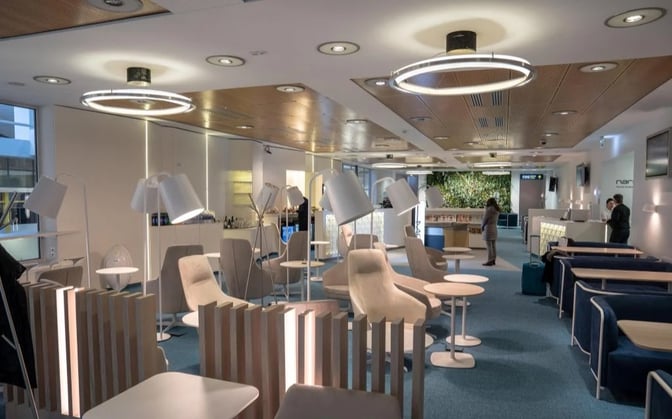 The Narbutas Business Lounge at Vilnius Airport features seating areas with tables and lamps, offering a comfortable space for travelers.