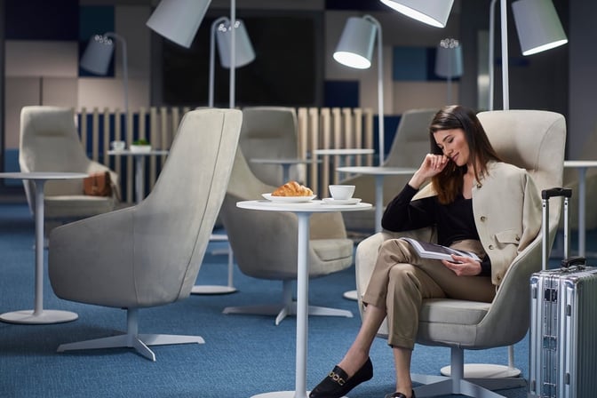 Comfortable seating in the Narbutas Business Lounge at Vilnius Airport features individual chairs and tables for relaxation and dining.