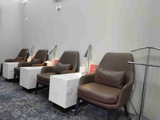 Seating area in Hayyak Lounge at Wadi al-Dawasir Airport features comfortable chairs with side tables and individual lamps for travelers.