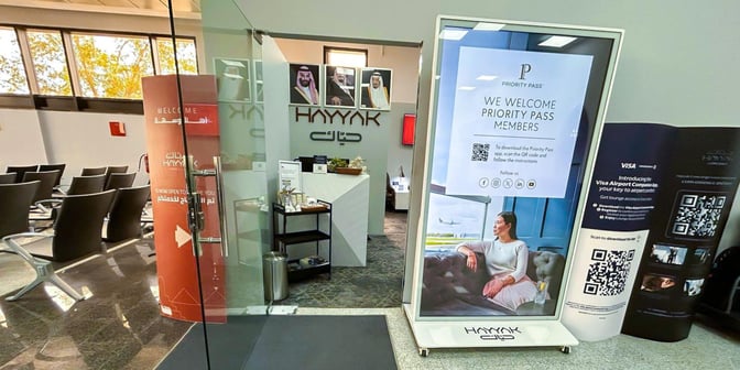 The entrance to Hayyak Lounge at Wadi al-Dawasir Domestic Airport features a reception desk and seating area visible through glass doors.