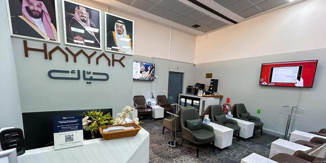 The Hayyak Lounge at Wadi al-Dawasir Domestic Airport features comfortable seating, a beverage station, and informational displays for travelers.