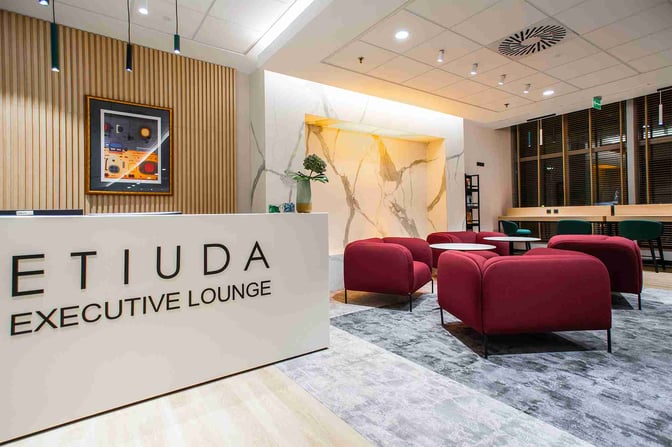 The Etiuda Executive Lounge at Warsaw Chopin Airport features a reception area with comfortable seating and workstations for travelers.