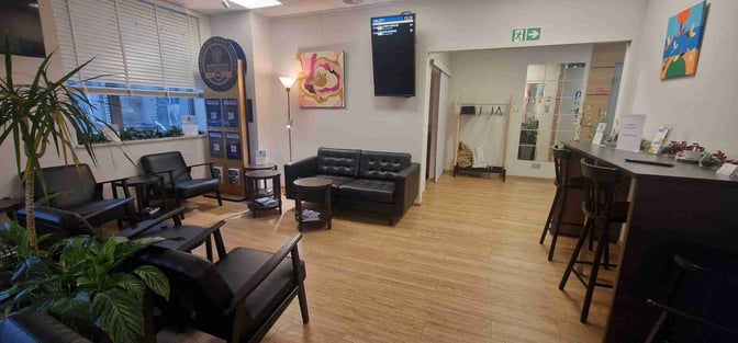 The Mazovia Premium Lounge at Warsaw-Modlin Airport features seating areas with armchairs and sofas, a coat rack, and a bar counter.