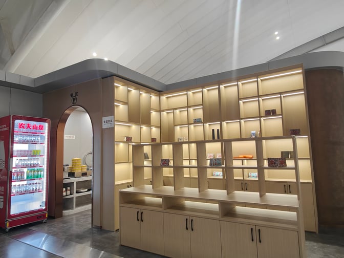 The V16 VIP Lounge at Wuhan Tianhe International Airport features a beverage station with a vending machine and display shelves.