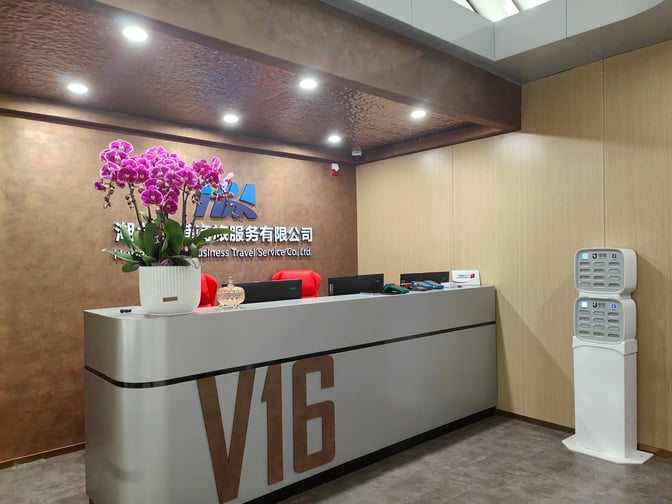 The V16 VIP Lounge reception at Wuhan Tianhe International Airport features a check-in counter with seating and a charging station.