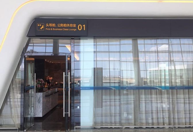 The entrance to the First and Business Class Lounge at Wuhan Tianhe International Airport features glass doors and a reception area.
