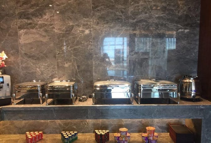 The First Class Lounge at Wuhan Tianhe International Airport features a self-serve buffet with chafing dishes and a variety of snacks.