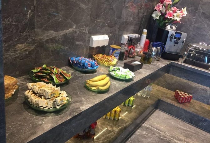 Self-serve snack station in the First Class Lounge at Wuhan Tianhe International Airport offers fruits, packaged snacks, and beverages.