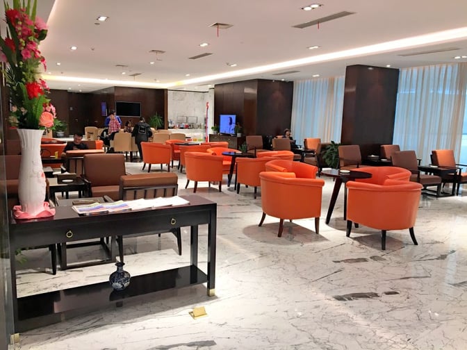 The No. 6 Domestic First/Business Class Lounge at Wuhan Tianhe International Airport features seating areas with tables and a self-serve refreshment station.
