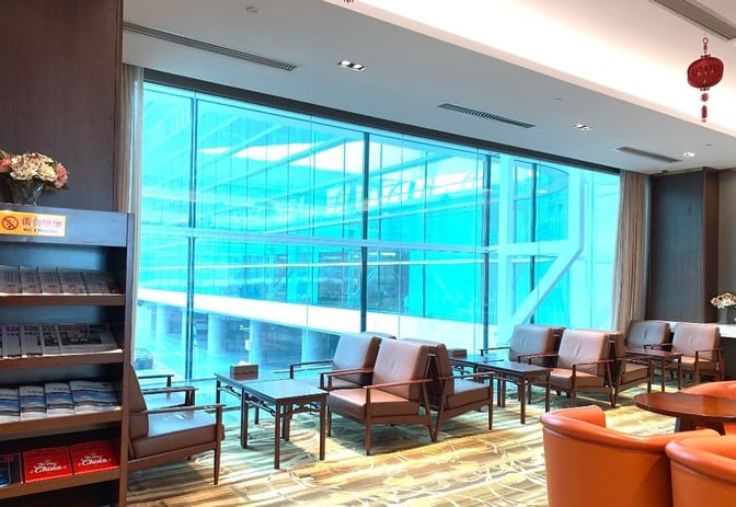Seating area in First Class Lounge No.8 at Wuhan Tianhe International Airport features armchairs and tables with views of the terminal.