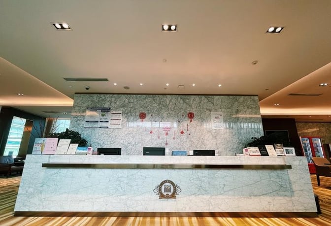 The reception desk at First Class Lounge No.8 in Wuhan Tianhe International Airport provides check-in services with informational displays.