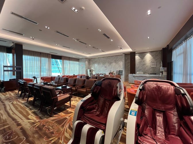 The No.5 Domestic First Class Lounge at Wuhan Tianhe International Airport features massage chairs and seating areas with tables for relaxation.