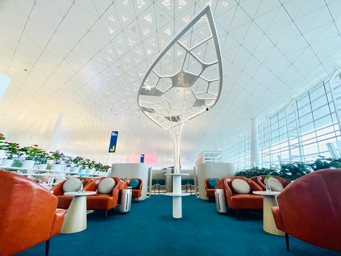 The VIP Reception No.1 lounge at Wuhan Tianhe International Airport features comfortable seating with tables, surrounded by decorative plants and a spacious layout.