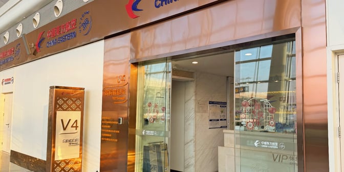 The entrance to the V4 China Eastern Lounge at Wuhan Tianhe International Airport features glass doors and signage indicating VIP access.