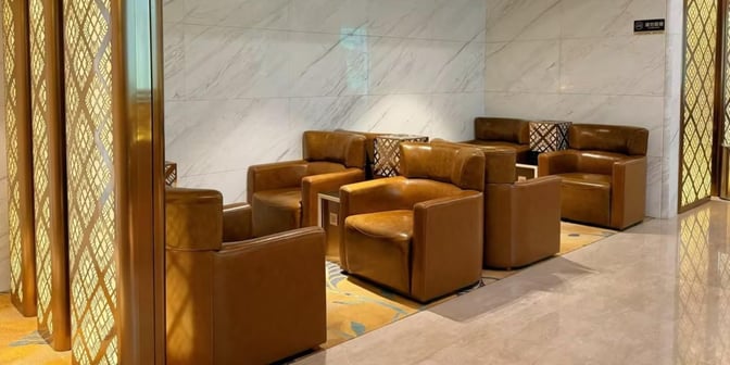The seating area in the V4 China Eastern Lounge at Wuhan Tianhe International Airport features comfortable armchairs arranged around small tables.