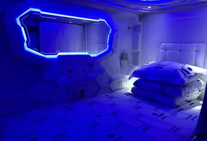 The nap lounge at Xi'an Xianyang International Airport features a futuristic sleeping pod with bedding and ambient lighting for hourly rental.