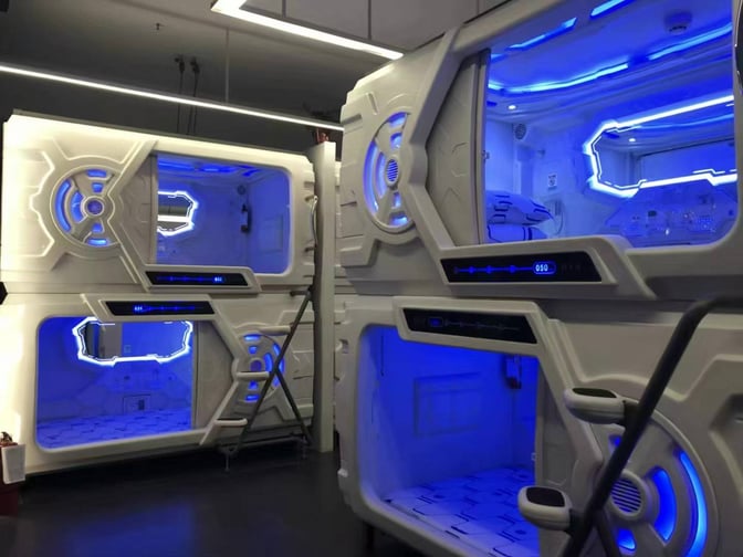 Sleeping pods at Xi'an Xianyang International Airport lounge offer private resting spaces with ladders for access and illuminated interiors.