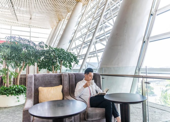 A seating area in Xiamen Gaoqi International Airport's First Class Lounge features plush chairs, small tables, and large windows with airport views.