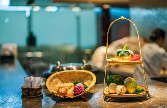 A food display in the First Class Lounge at Xiamen Gaoqi International Airport features fresh vegetables and a selection of noodles.