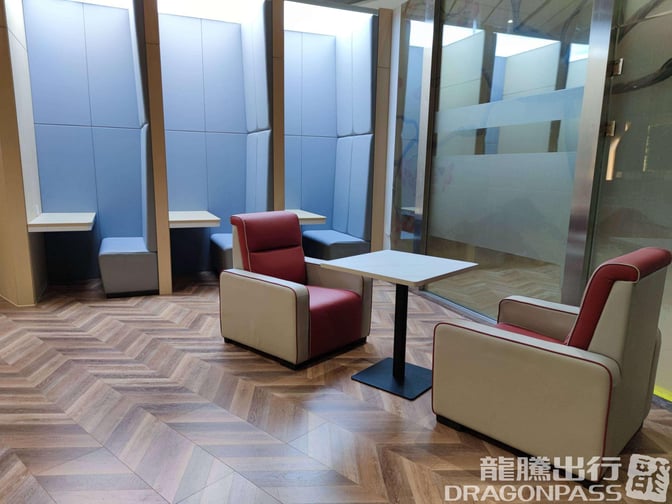 Semi-private seating in the China Southern Pearl Lounge at Xi'an Xianyang Airport features individual booths and armchairs with small tables.