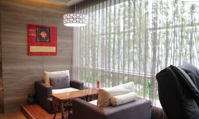 Seating area in Xi'an Xianyang International Airport's First Class Lounge No. 3 features cushioned chairs and a table near large windows.