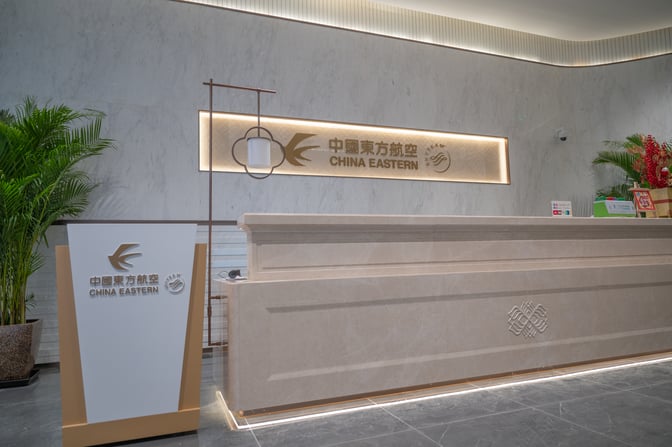The reception area of China Eastern Lounge at Xi'an Xianyang International Airport features a service desk and branded signage.