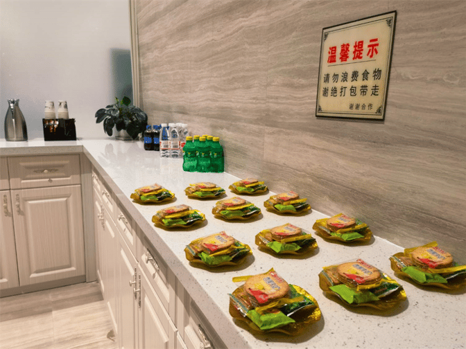 The First Class Lounge at Xingyi Wanfenglin Airport features a self-serve snack station with packaged snacks and bottled beverages.