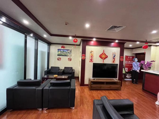 The First Class Lounge at Xishuangbanna Gasa Airport features comfortable seating, a television, and a staffed reception area.