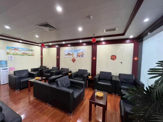 The seating area in the First Class Lounge at Xishuangbanna Gasa Airport features arranged armchairs and small tables for passenger comfort.