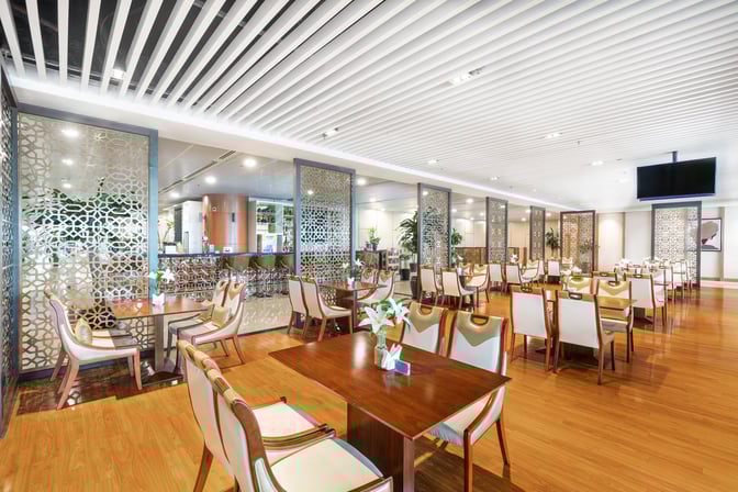 The Mingalar Sky Business Class Lounge at Yangon International Airport features a spacious dining area with tables and chairs for travelers.