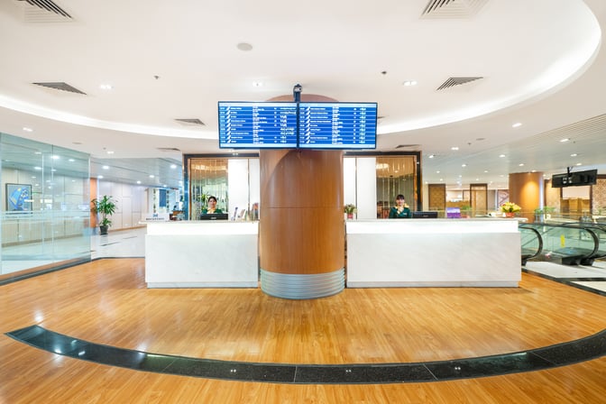 The reception area of Mingalar Sky Business Class Lounge at Yangon International Airport features check-in counters and flight information displays.