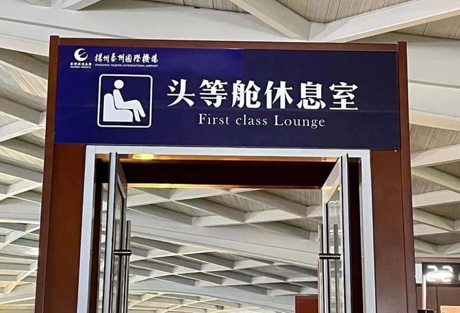 The entrance to the First Class Lounge at Yangzhou Taizhou Airport features a sign with lounge access information.