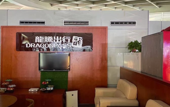 The lounge area at Yangzhou Taizhou Airport features comfortable seating, a television, and a selection of snacks on display.