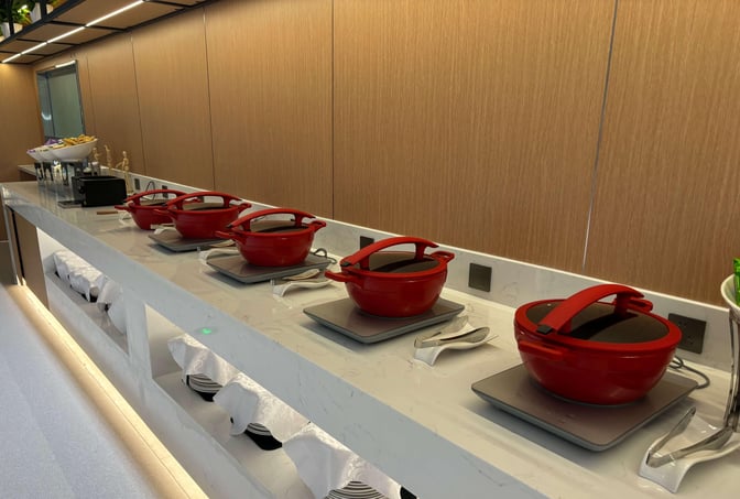 The First Class Lounge at Yinchuan Hedong International Airport features a self-serve food area with hot dishes in red pots.