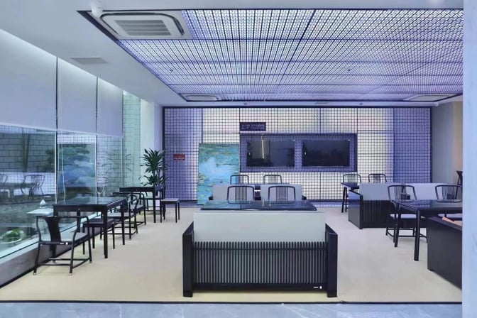 The First Class Lounge at Yiwu Airport features seating areas with tables, chairs, and a decorative wall, offering a comfortable waiting space.