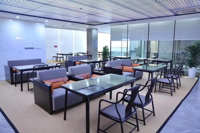 The seating area in Yiwu Airport's First Class Lounge features glass-topped tables and cushioned chairs, providing a comfortable waiting space.