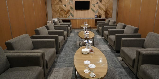 The Concordia Lounge at Yogyakarta International Airport features a seating area with armchairs and tables set with glasses and snacks.