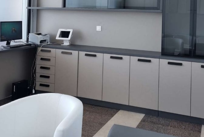 The Zadar Airport Business Lounge features a workstation with a computer, printer, and ample storage cabinets for traveler convenience.