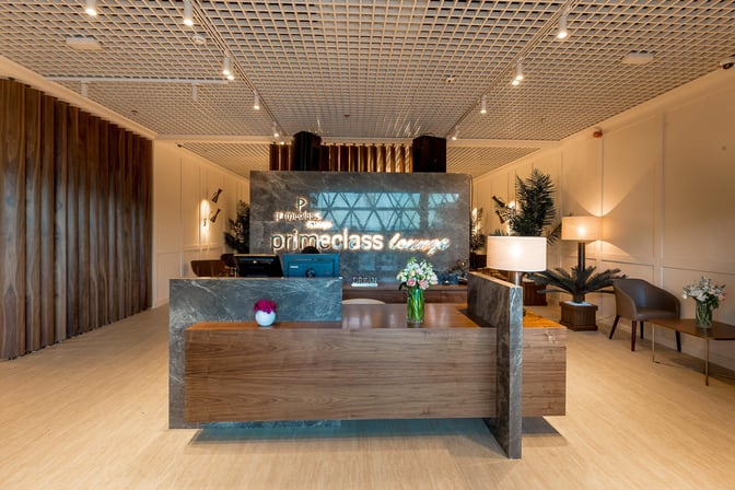 The Primeclass Lounge entrance at Zagreb Airport features a reception desk with seating and decorative plants nearby.