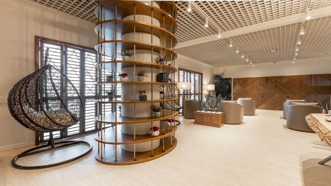 The Primeclass Lounge at Zagreb Airport features a seating area with round chairs, decorative shelving, and a hanging chair for relaxation.